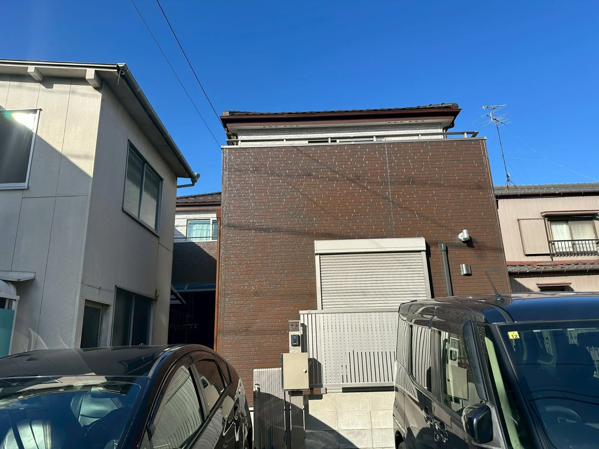 「一軒の塗り替えから、広がる信頼の輪。アイダ設計の機能美と、お隣の工場を守る『男前』なハンガードア塗装。」